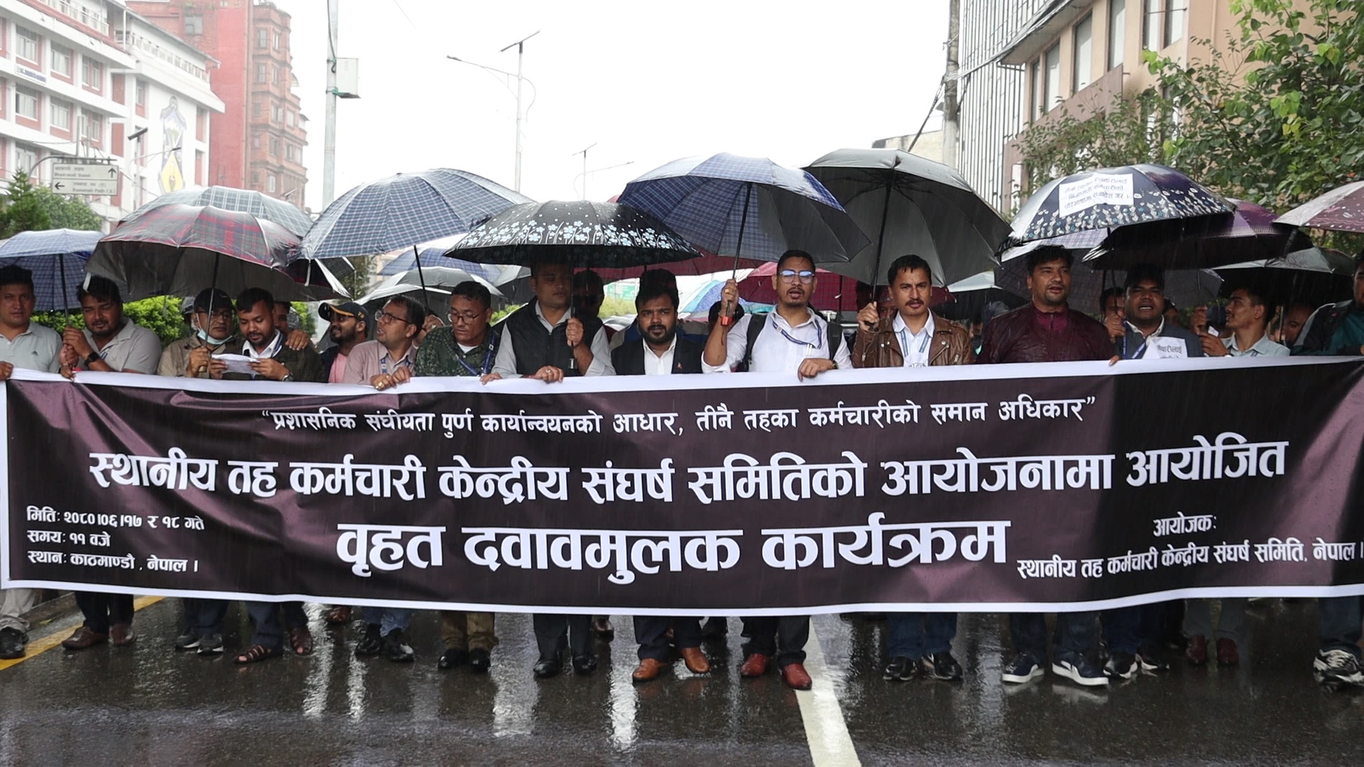 वर्षा भइरहँदा पनि छाता ओढेर आन्दोलन गरिरहेका छन् स्थानीय तहका कर्मचारी (तस्वीरहरू)